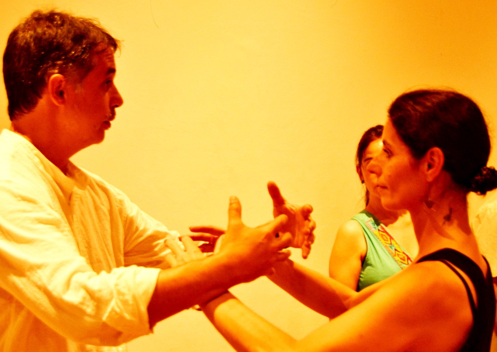 Two people facing each other, hands meeting in the air